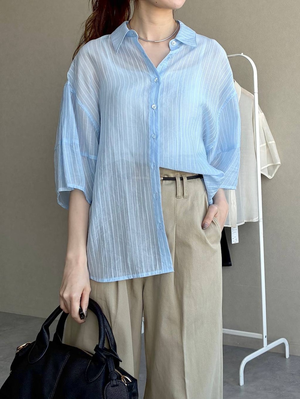 ブラック系のボストンバッグ、ブラック系のローファー、ブルー系のシャツ/ブラウスを着用したレディースの春コーディネートの5枚目の写真