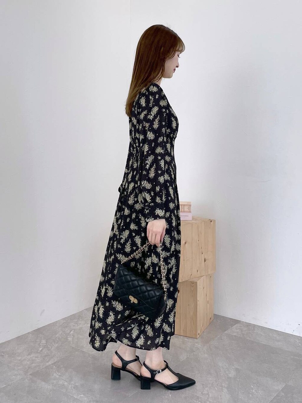 ブラック系のワンピース、ブラック系のショルダーバッグ、ブラック系のパンプスを着用したレディースの春コーディネートの2枚目の写真