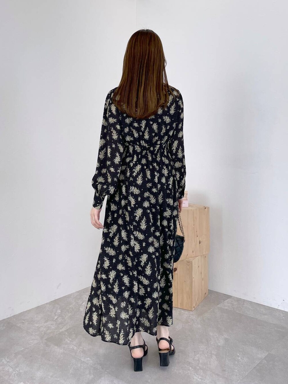 ブラック系のワンピース、ブラック系のショルダーバッグ、ブラック系のパンプスを着用したレディースの春コーディネートの3枚目の写真