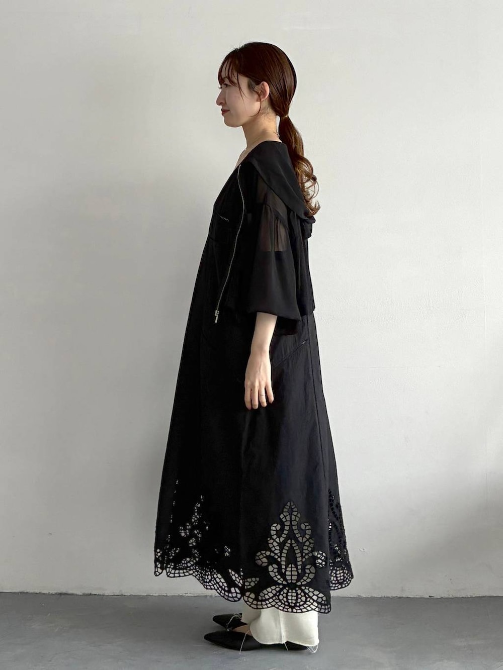 ブラック系のパーカー、ブラック系のパンプス、グリーン系のハンドバッグを着用したレディースの春コーディネートの2枚目の写真