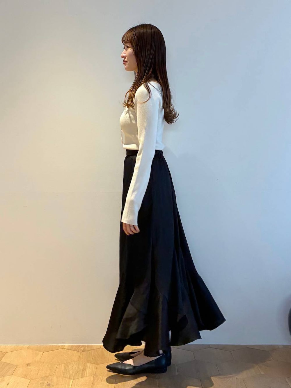 ブラック系のパンプス、ホワイト系のニット/セーター、ホワイト系のノーカラージャケットを着用したレディースの春コーディネートの7枚目の写真