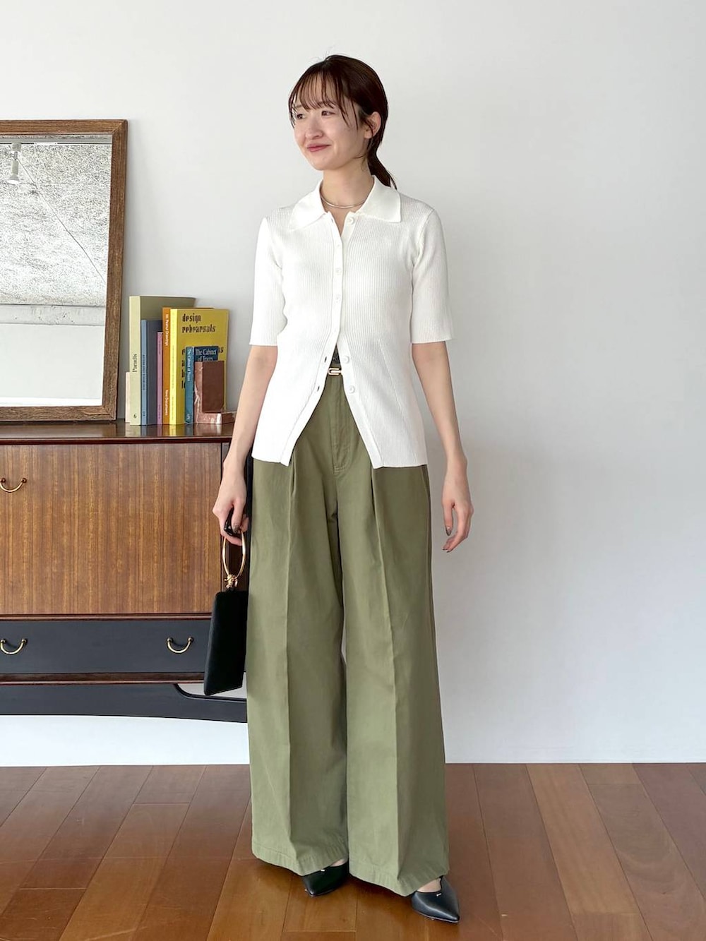 ブラック系のパンプス、ブラック系のショルダーバッグ、ホワイト系のカーディガン/ボレロを着用したレディースの春コーディネートの5枚目の写真