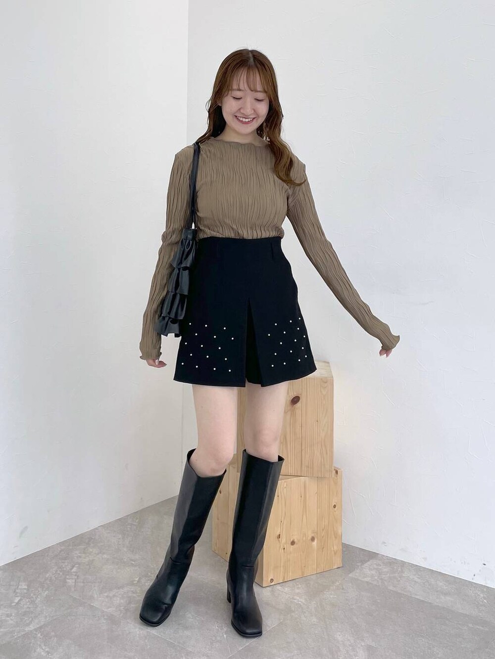 ブラック系のブーツ、ブラウン系のTシャツ/カットソー、ホワイト系のニット/セーターを着用したレディースの秋コーディネートの6枚目の写真