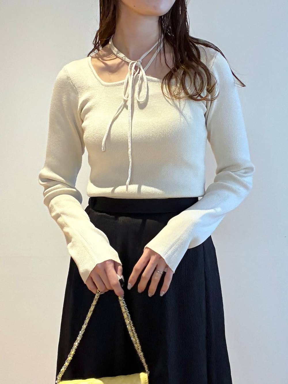 ブラック系のパンプス、ホワイト系のニット/セーター、ホワイト系のノーカラージャケットを着用したレディースの春コーディネートの9枚目の写真