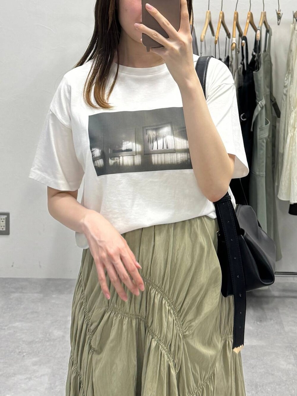 ブラック系のサンダル、ブラック系のショルダーバッグ、グリーン系のスカートを着用したレディースの夏コーディネートの3枚目の写真