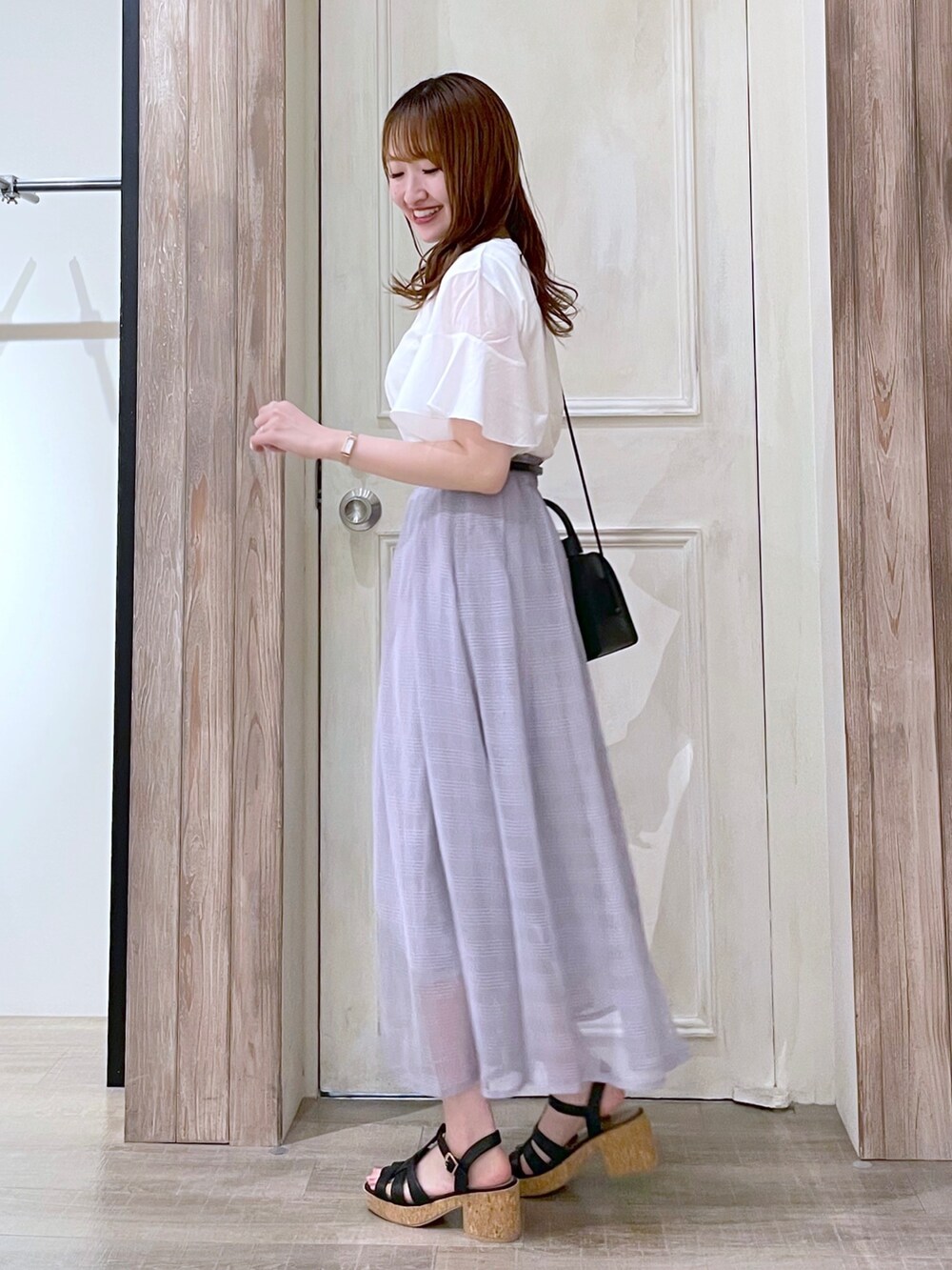 ホワイト系のTシャツ/カットソー、グレー系のスカート、ブラック系のサンダルを着用したレディースの夏コーディネートの2枚目の写真