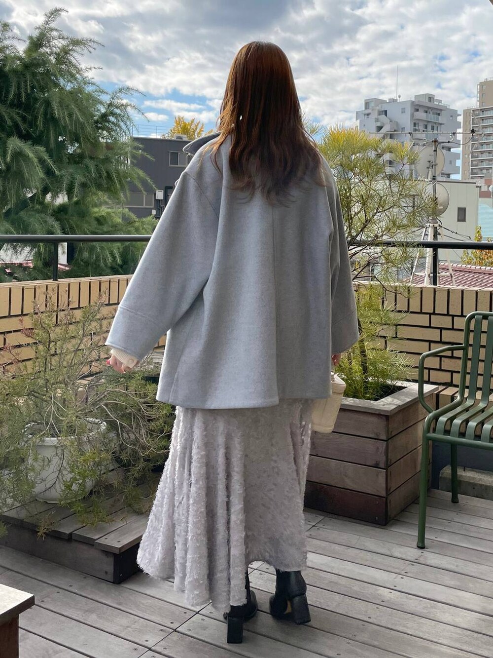 グレー系のブーツ、ホワイト系のニット/セーター、ホワイト系のショルダーバッグを着用したレディースの冬コーディネートの2枚目の写真