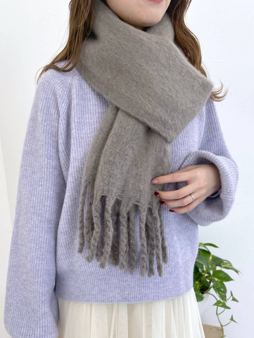 パープル系のニット/セーター、グレー系のブーツ、ホワイト系のショルダーバッグを着用したレディースの冬コーディネートの5枚目の写真