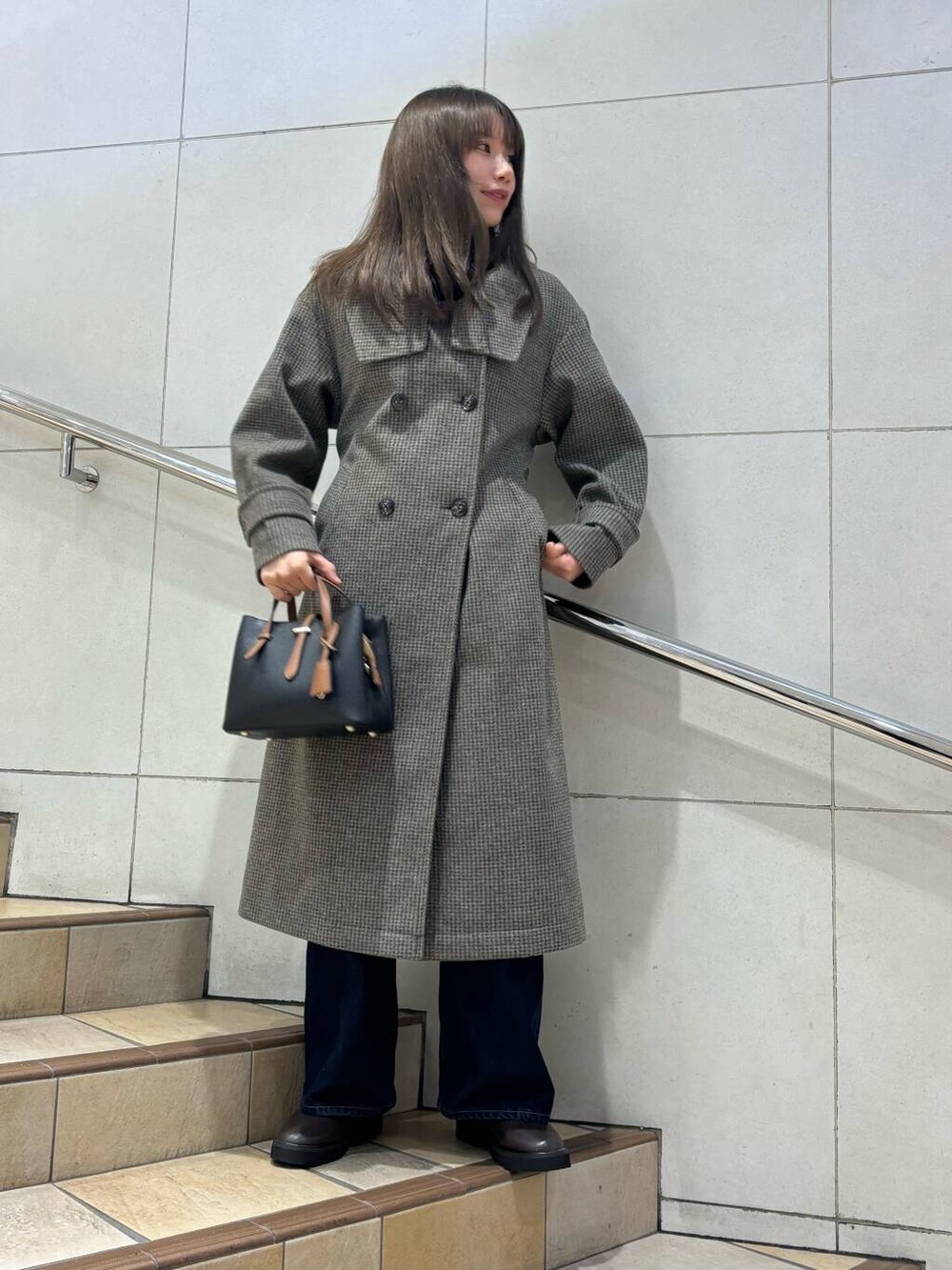 ブラック系のトートバッグ、ブラック系のニット/セーター、ブラウン系のブーツを着用したレディースの冬コーディネートの2枚目の写真