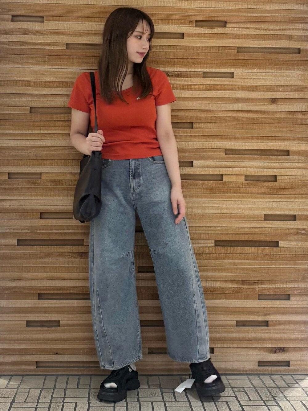 レッド系のTシャツ/カットソー、ブルー系のデニムパンツ、ブラック系のショルダーバッグを着用したレディースの夏コーディネートの2枚目の写真
