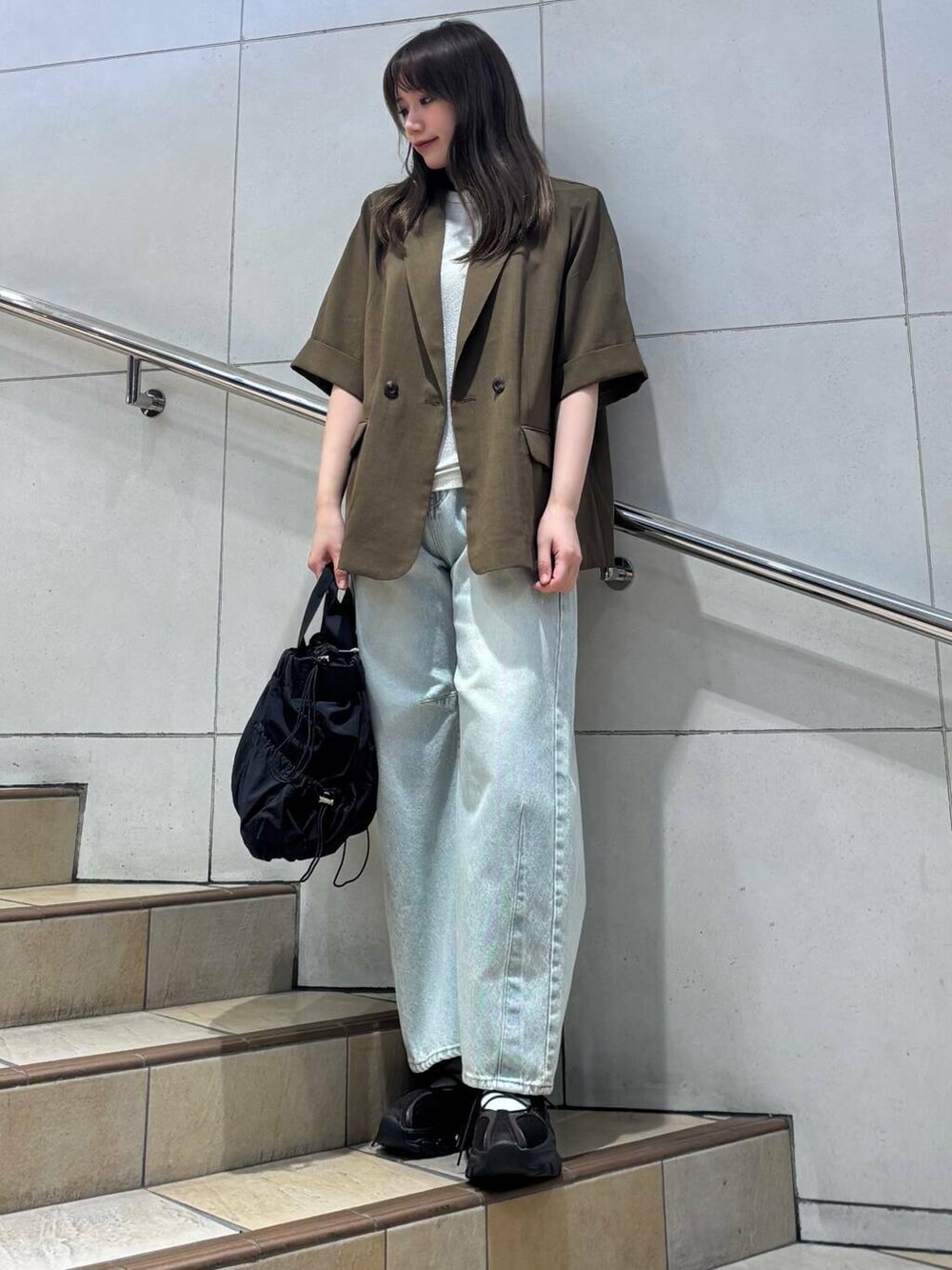 シルバー系のTシャツ/カットソー、ブルー系のデニムパンツ、ブラック系のショルダーバッグを着用したレディースの夏コーディネートの2枚目の写真