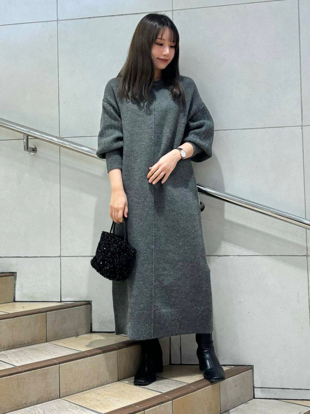 ブラック系のショルダーバッグ、ブラック系のブーツ、ベージュ系のその他アウターを着用したレディースの冬コーディネートの4枚目の写真