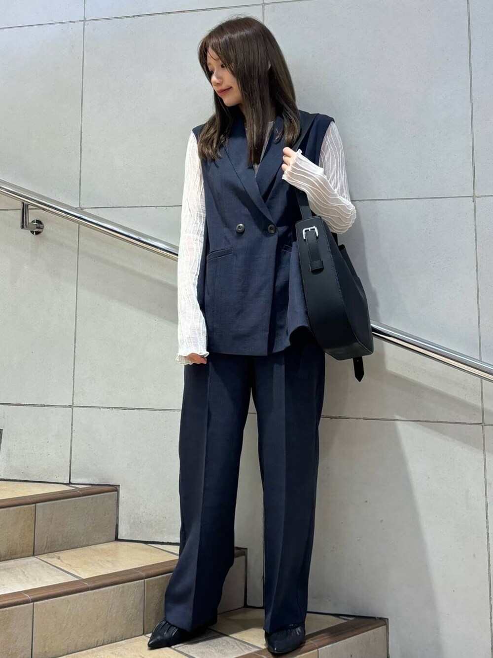 ブラック系のバレエシューズ、ブラック系のショルダーバッグ、ホワイト系のキャミソールを着用したレディースの春コーディネートの2枚目の写真