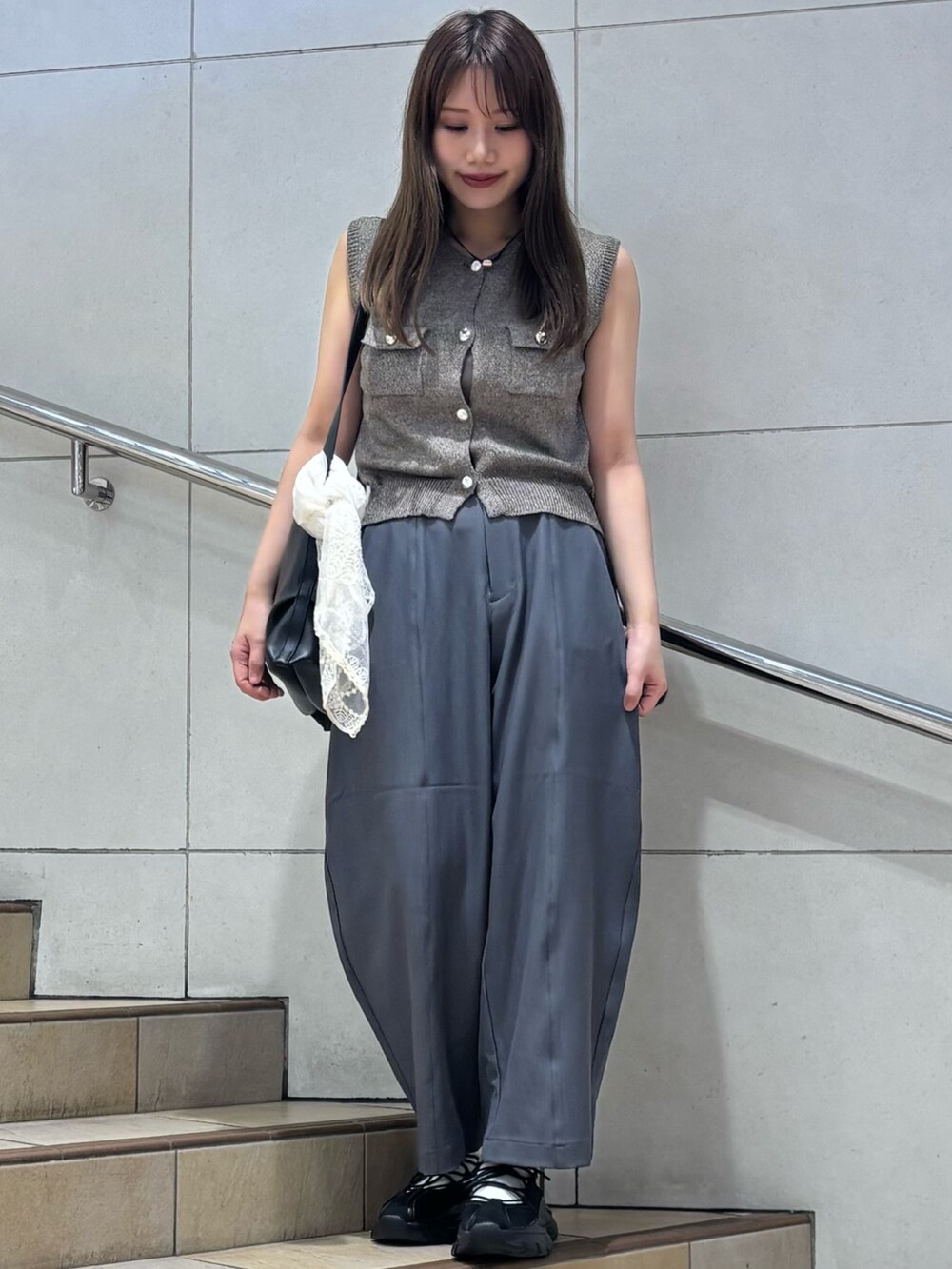 グレー系のその他パンツ、ブラック系のスニーカー、ブラック系のショルダーバッグを着用したレディースの夏コーディネートの2枚目の写真