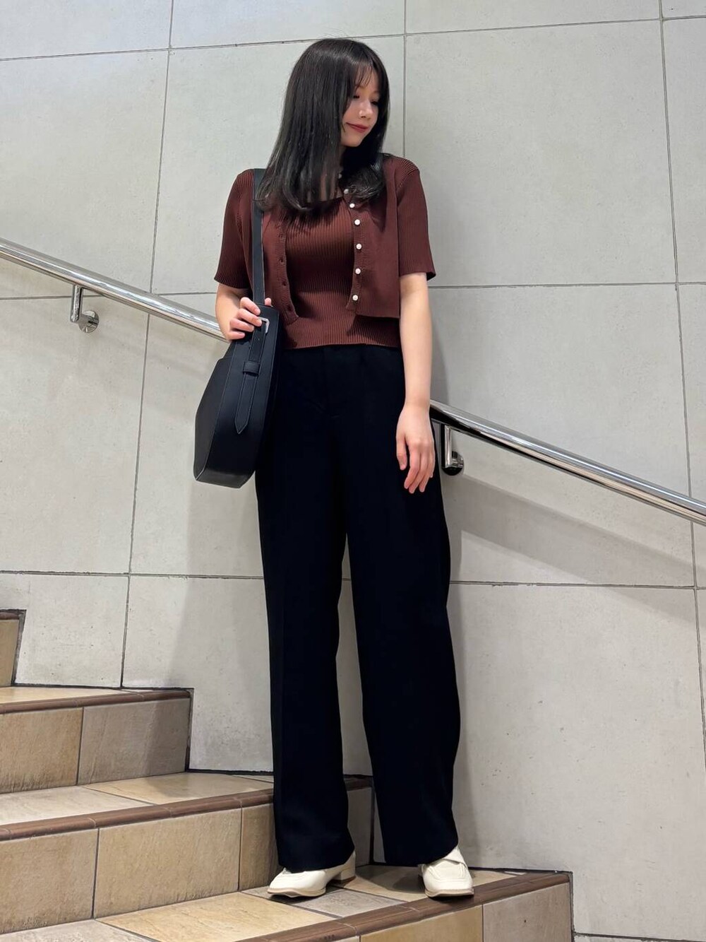 ブラック系のショルダーバッグ、ホワイト系のローファー、ブラック系のその他パンツを着用したレディースの春コーディネートの2枚目の写真