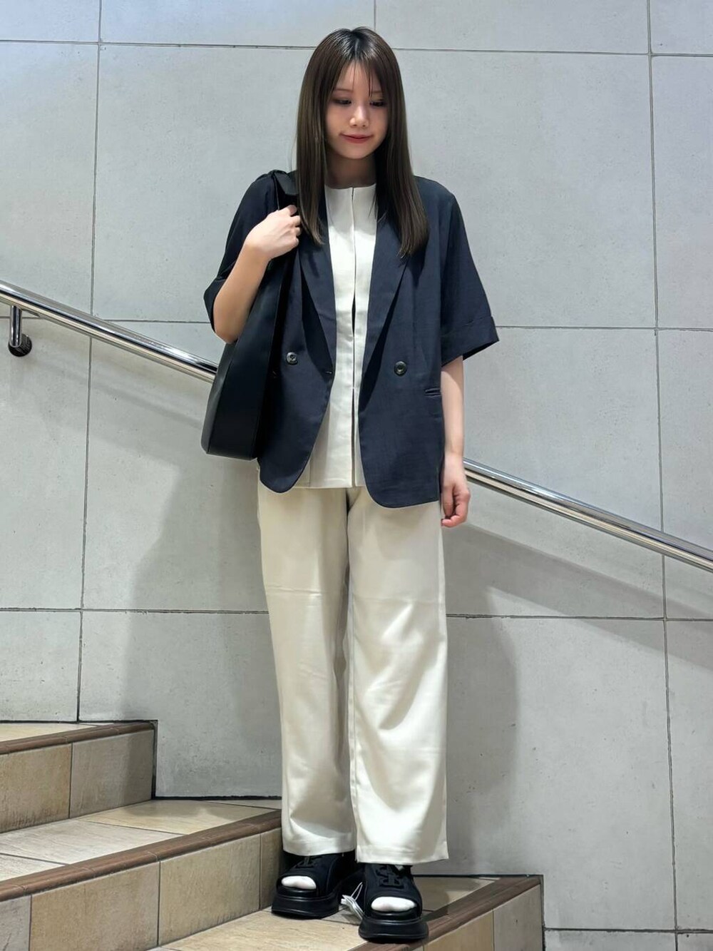 ブラック系のショルダーバッグ、グレー系のその他アウター、ブラック系のサンダルを着用したレディースの春コーディネートの4枚目の写真