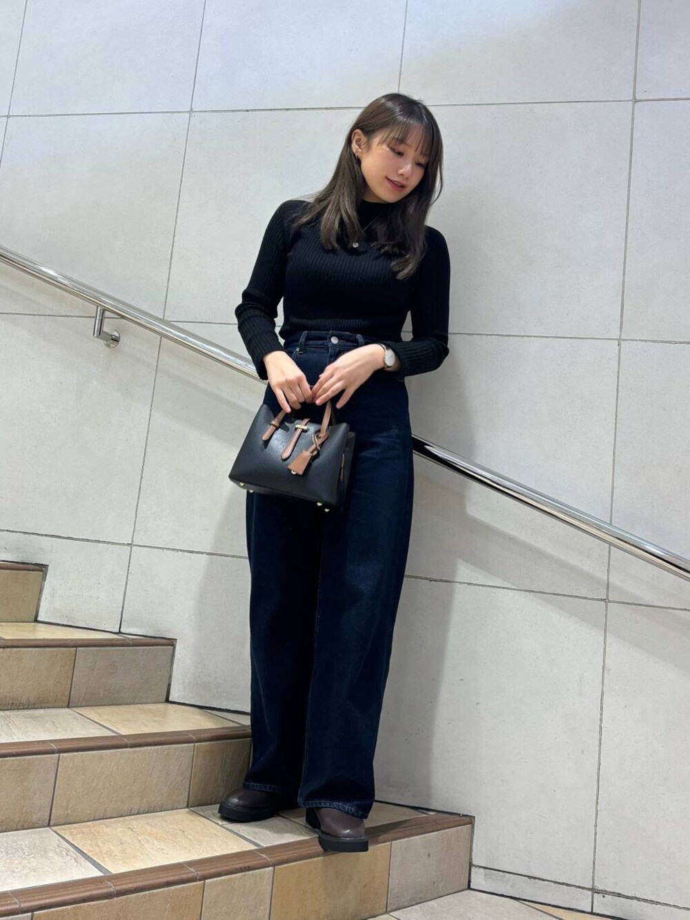 ブラック系のトートバッグ、ブラック系のニット/セーター、ブラウン系のブーツを着用したレディースの冬コーディネートの3枚目の写真