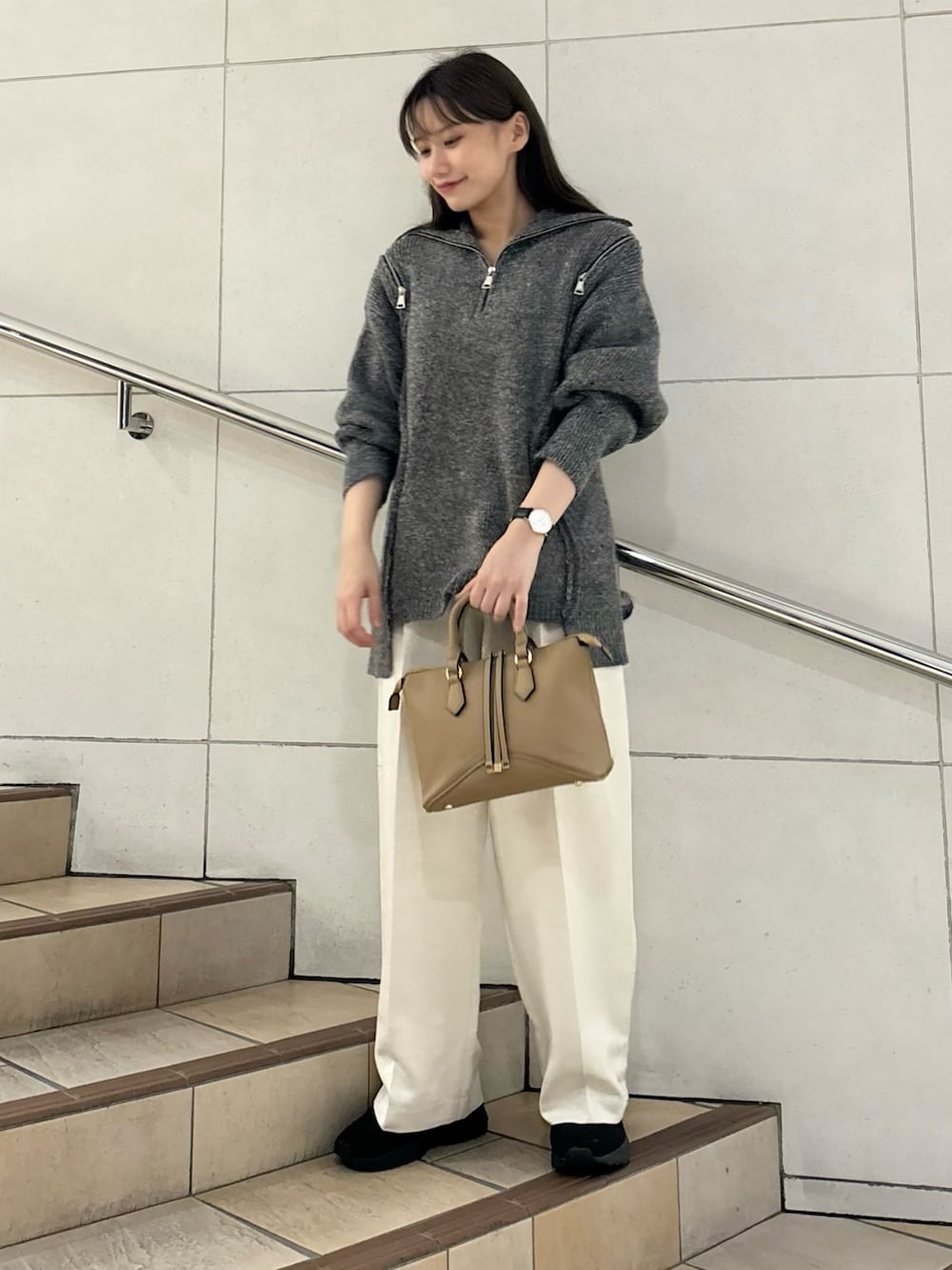 グレー系のニット/セーター、ホワイト系のその他パンツ、ブラウン系のボストンバッグを着用したレディースの秋コーディネートの2枚目の写真