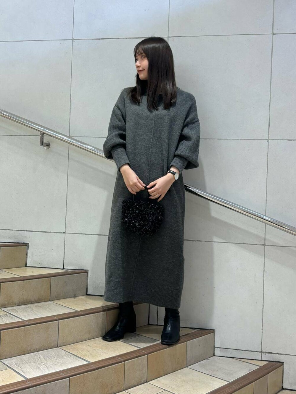 ブラック系のショルダーバッグ、ブラック系のブーツ、ベージュ系のその他アウターを着用したレディースの冬コーディネートの3枚目の写真