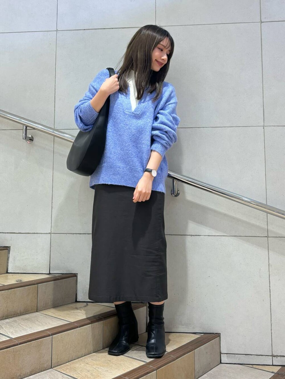 ブラック系のブーツ、グレー系のスカート、ブルー系のニット/セーターを着用したレディースの冬コーディネートの4枚目の写真