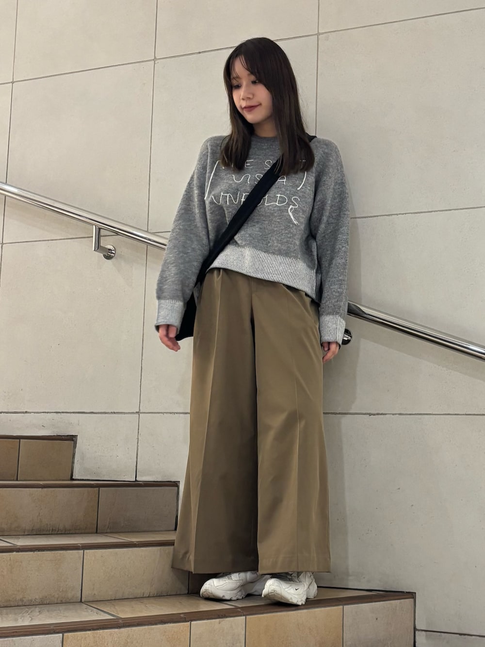 グリーン系のニット/セーター、ベージュ系のその他パンツを着用したレディースの秋コーディネートの2枚目の写真