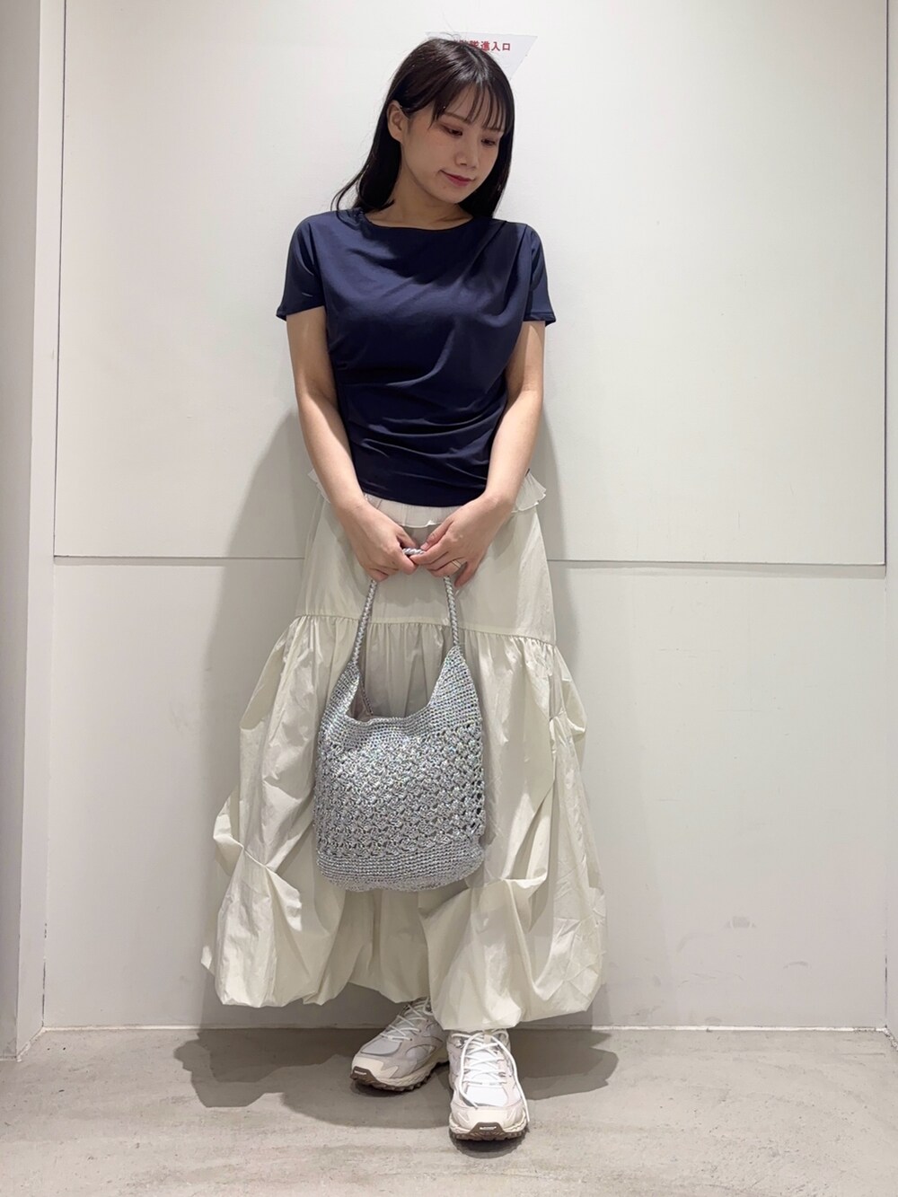 ブルー系のTシャツ/カットソー、ホワイト系のスカート、シルバー系のかごバッグを着用したレディースの春コーディネートの2枚目の写真
