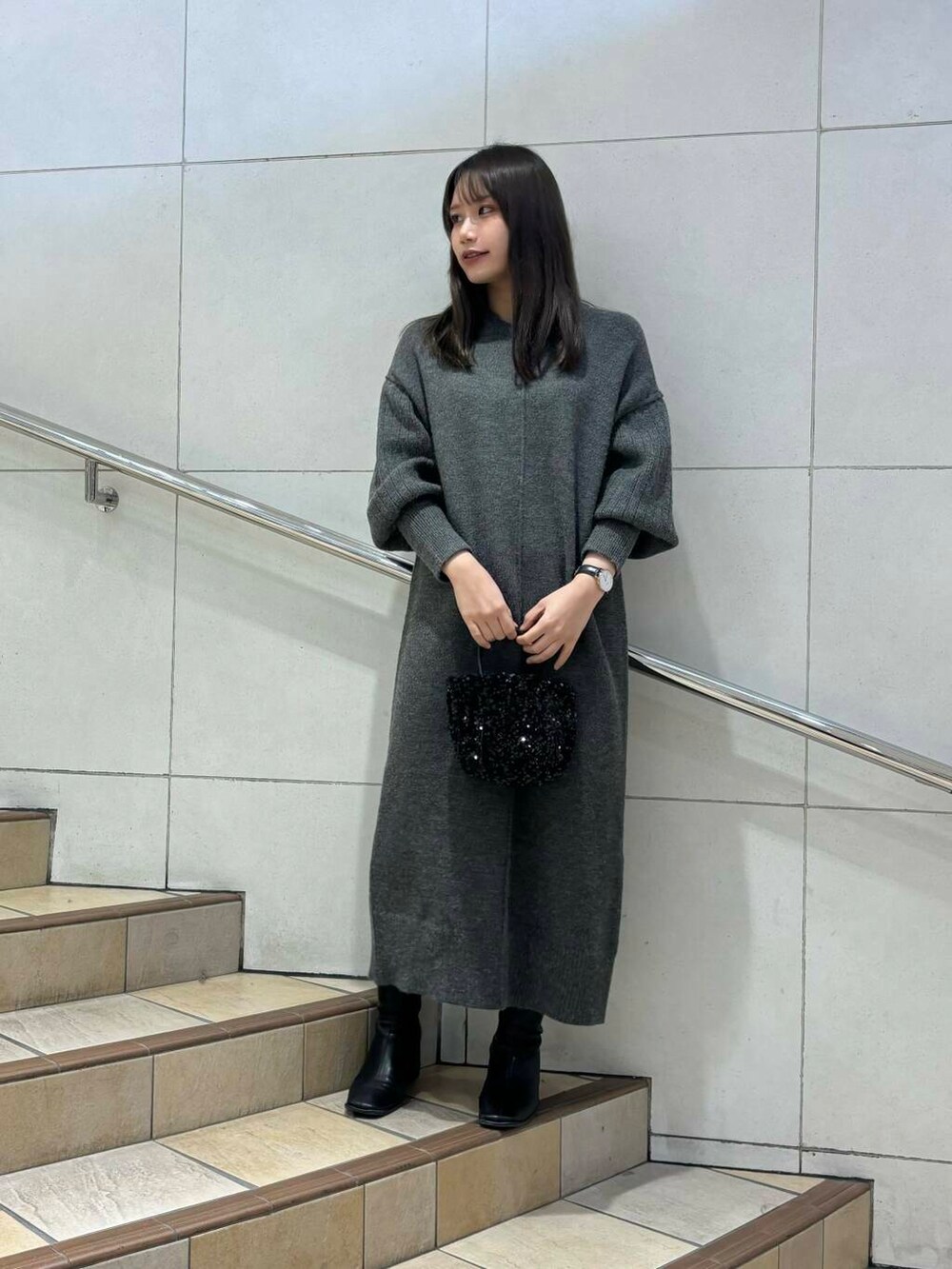 ブラック系のショルダーバッグ、ブラック系のブーツ、ベージュ系のその他アウターを着用したレディースの冬コーディネートの2枚目の写真