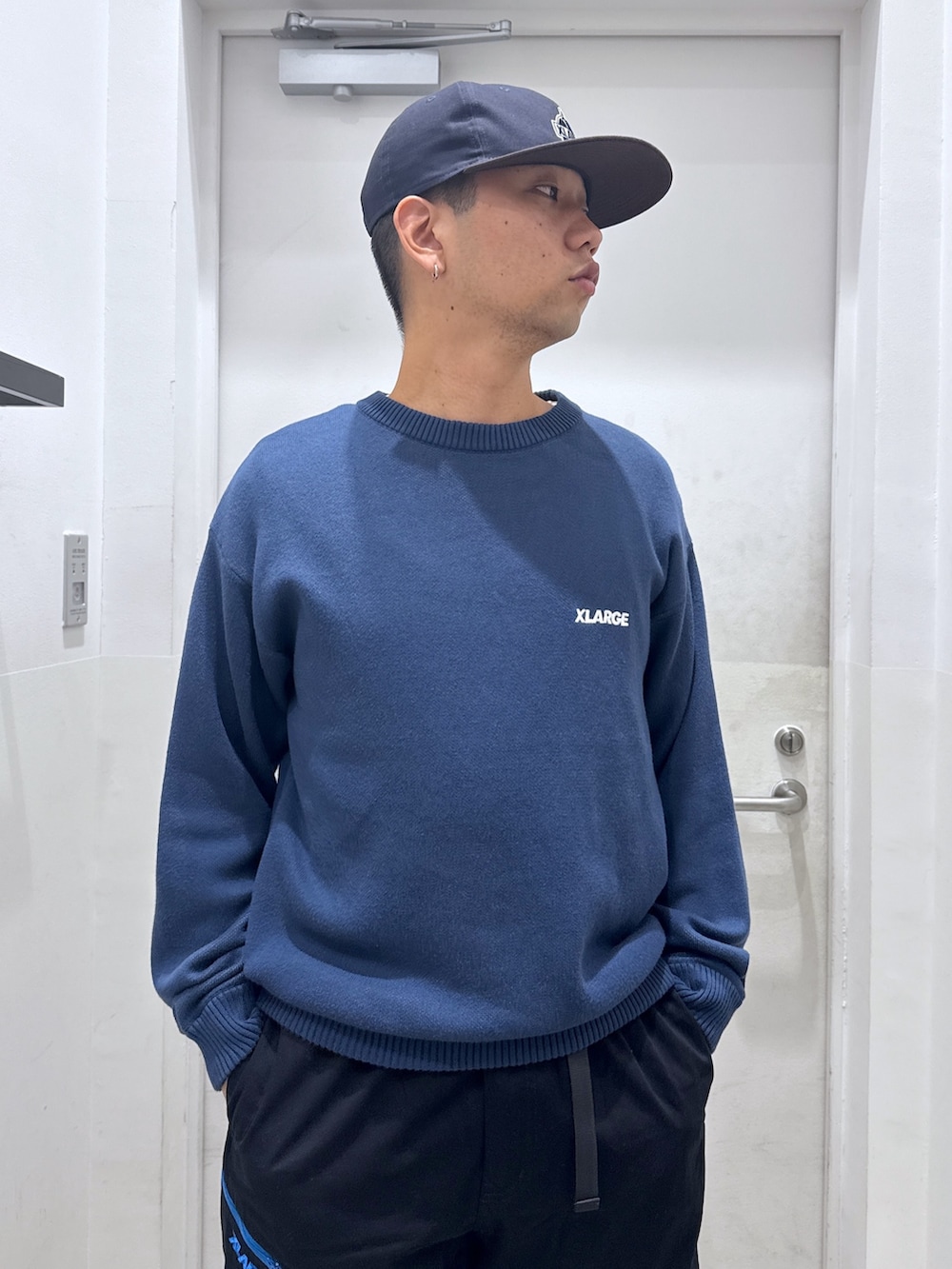 ブルー系のニット/セーター、ブラック系のその他パンツ、ブルー系のキャップを着用したメンズの秋コーディネートの5枚目の写真