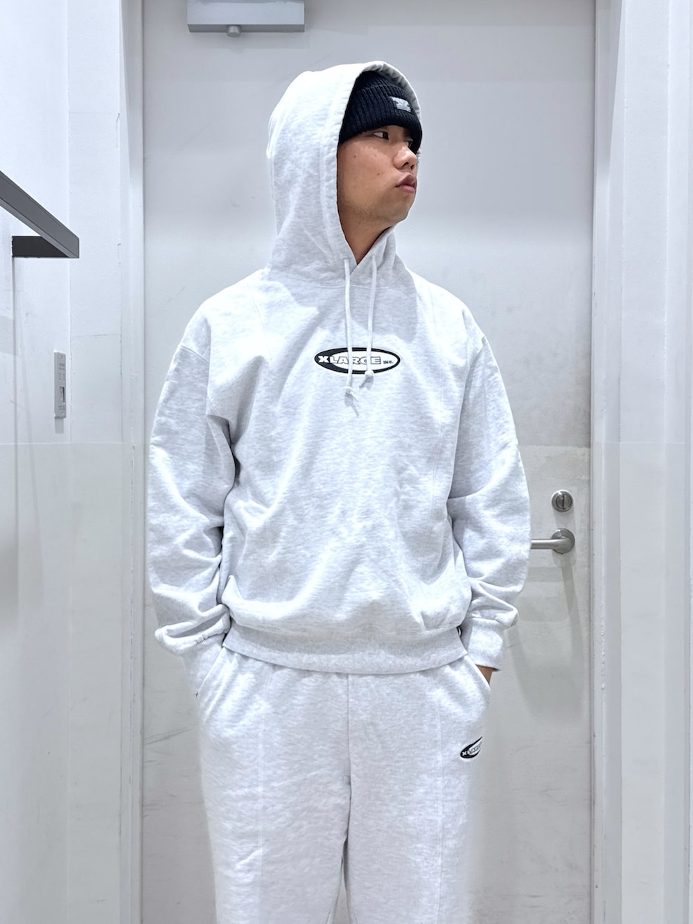 ブラック系のデニムジャケット、グレー系のパーカー、グレー系のスウェットパンツを着用したメンズの秋コーディネートの7枚目の写真