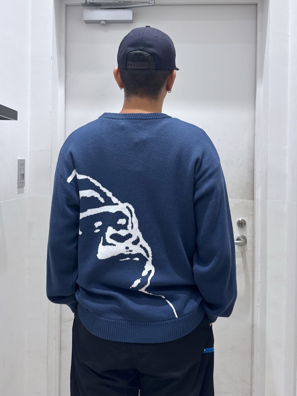 ブルー系のニット/セーター、ブラック系のその他パンツ、ブルー系のキャップを着用したメンズの秋コーディネートの6枚目の写真