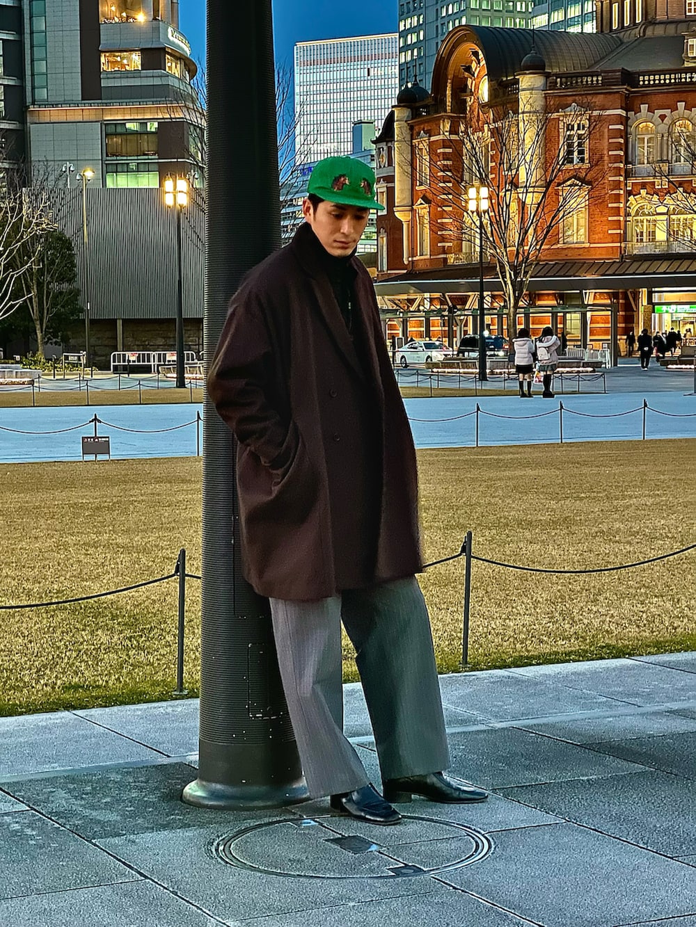 ブラウン系のチェスターコート、グレー系のスラックス、ブラック系のブーツを着用したメンズの冬コーディネートの2枚目の写真