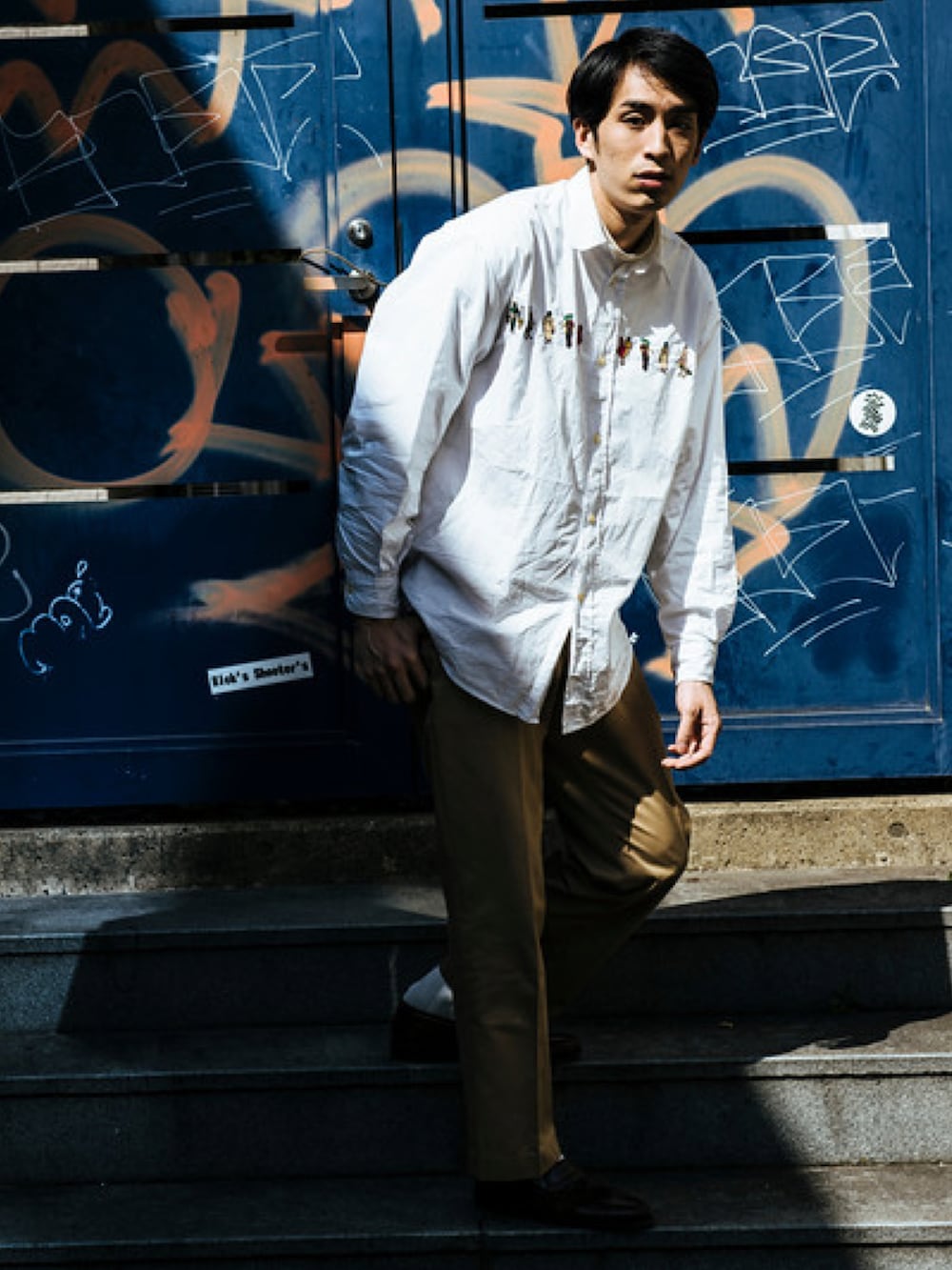 ホワイト系のシャツ/ブラウス、ベージュ系のチノパンツ、ブラウン系のローファーを着用したメンズの春コーディネートの2枚目の写真