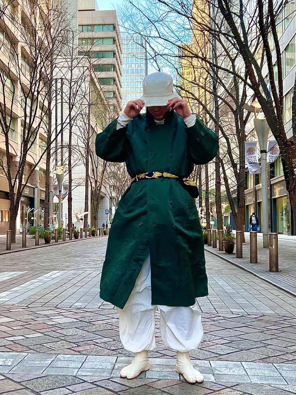 グリーン系のトレンチコート、ホワイト系のカーゴパンツ、ホワイト系のブーツを着用したメンズの冬コーディネートの2枚目の写真