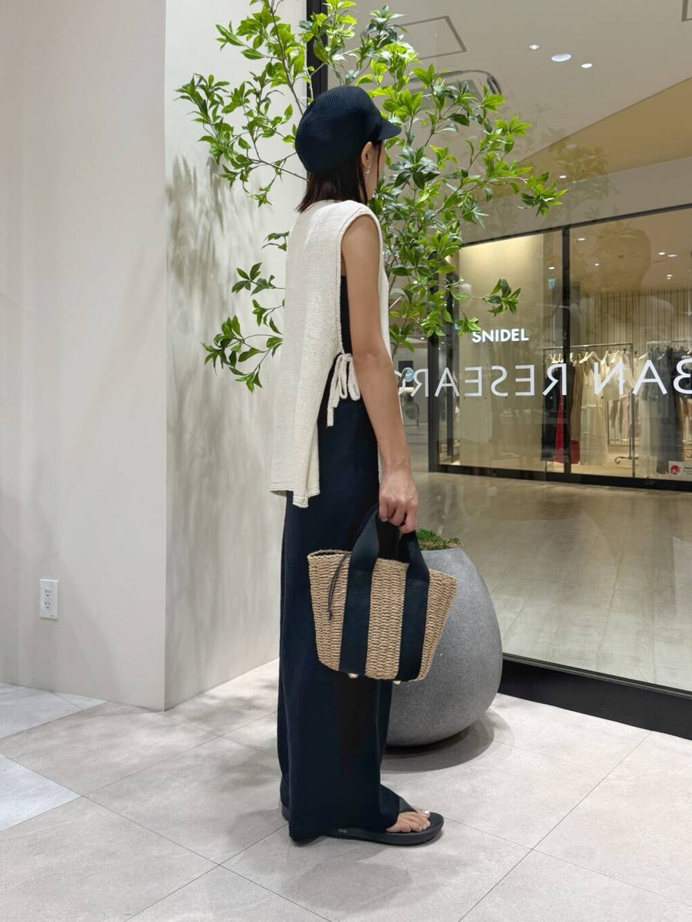 ブラック系のサンダル、ブラック系のその他パンツ、ベージュ系のハンドバッグを着用したレディースの夏コーディネートの3枚目の写真