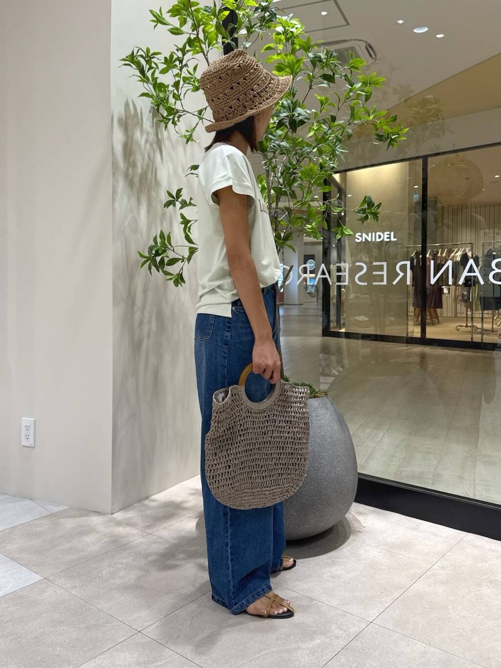 ブラウン系のサンダル、グレー系のトートバッグ、グリーン系のTシャツ/カットソーを着用したレディースの夏コーディネートの2枚目の写真