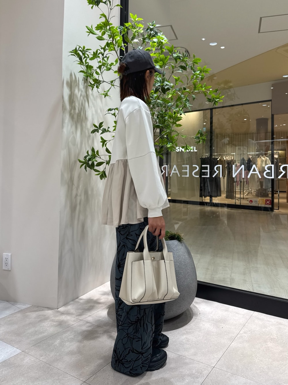 ホワイト系のTシャツ/カットソー、ブラウン系のその他パンツ、ホワイト系のトートバッグを着用したレディースの秋コーディネートの2枚目の写真