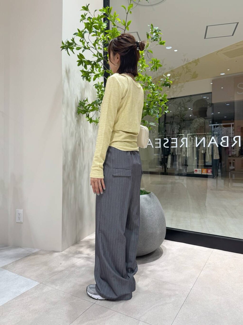 グレー系のサロペット/オーバーオール、ホワイト系のボストンバッグ、イエロー系のTシャツ/カットソーを着用したレディースの春コーディネートの2枚目の写真