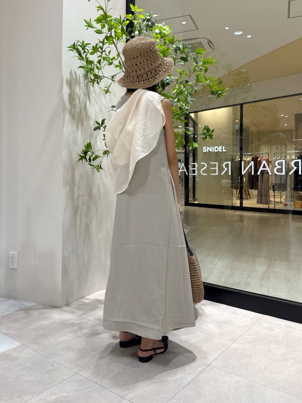 ホワイト系のシャツ/ブラウス、イエロー系のトートバッグ、ブラック系のサンダルを着用したレディースの夏コーディネートの2枚目の写真