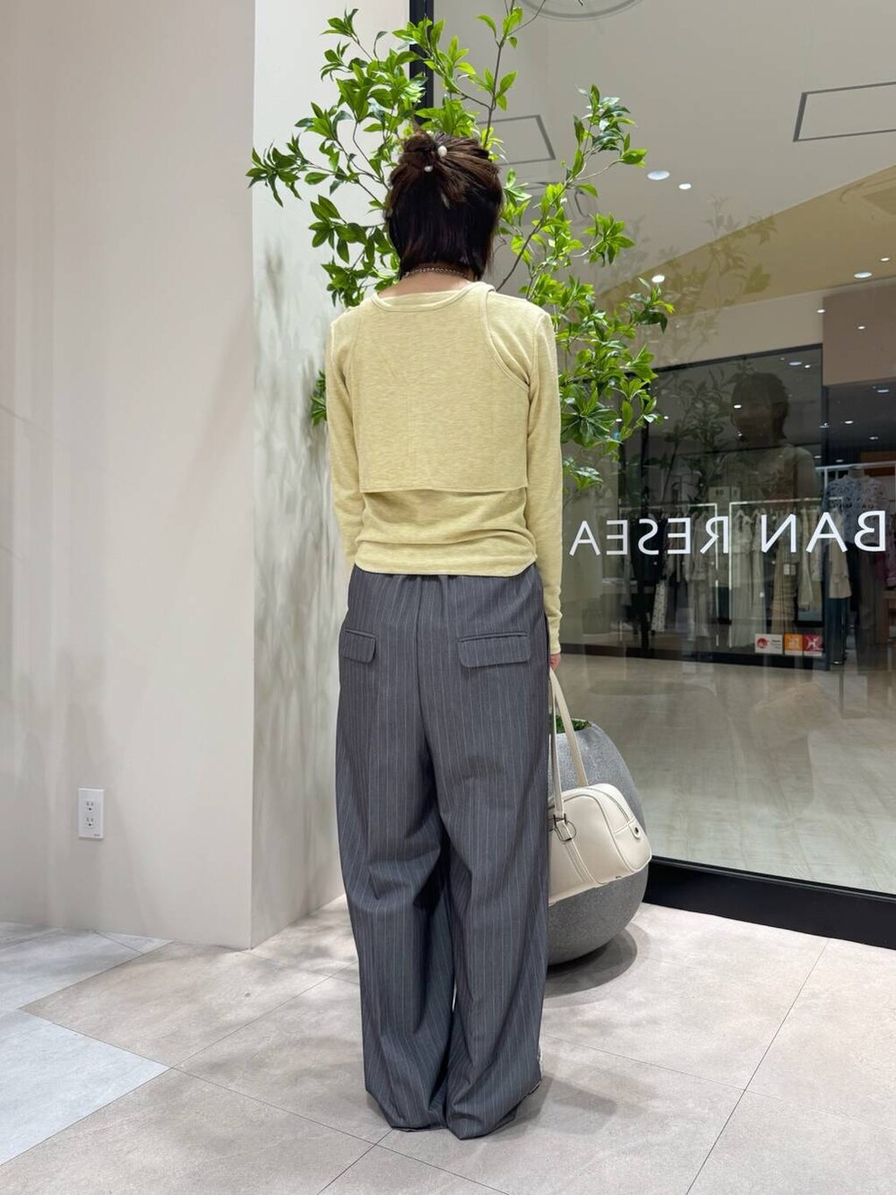 グレー系のサロペット/オーバーオール、ホワイト系のボストンバッグ、イエロー系のTシャツ/カットソーを着用したレディースの春コーディネートの3枚目の写真