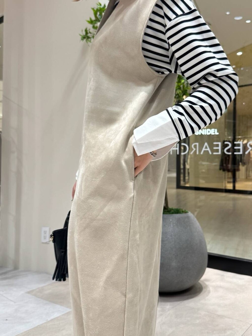 ブラック系のショルダーバッグ、ホワイト系のTシャツ/カットソー、グレー系のスニーカーを着用したレディースの冬コーディネートの4枚目の写真