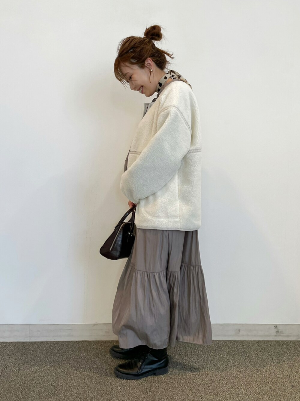 ホワイト系のその他アウター、ブラウン系のボストンバッグを着用したレディースの冬コーディネートの2枚目の写真