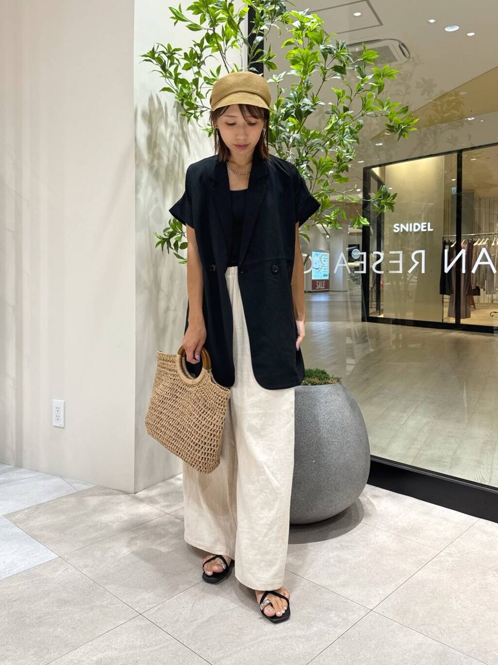 ベージュ系のその他パンツ、ブラック系のベスト、ベージュ系のトートバッグを着用したレディースの夏コーディネートの4枚目の写真