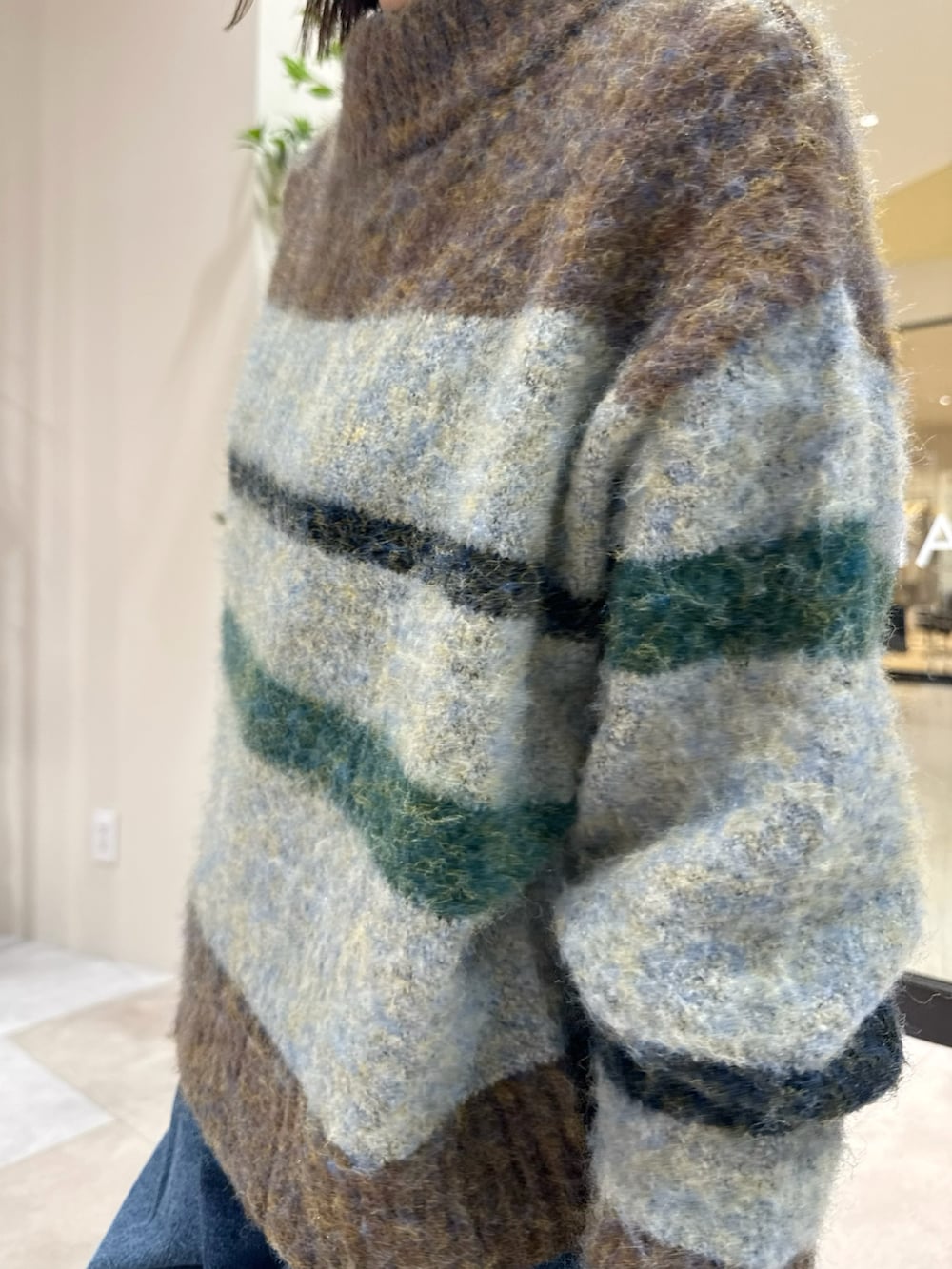 ブラウン系のニット/セーター、ホワイト系のTシャツ/カットソー、グリーン系のトートバッグを着用したレディースの秋コーディネートの5枚目の写真