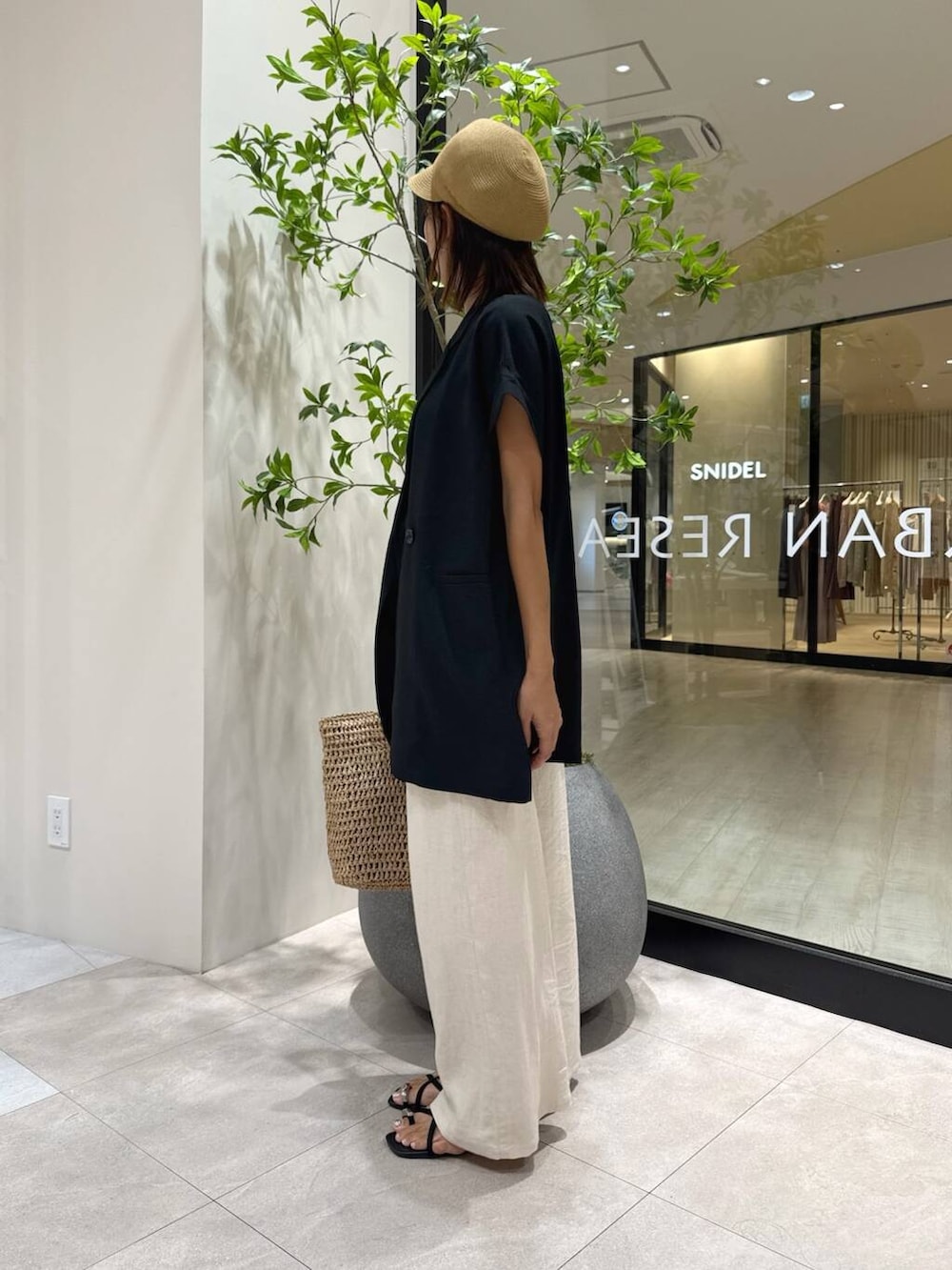 ベージュ系のその他パンツ、ブラック系のベスト、ベージュ系のトートバッグを着用したレディースの夏コーディネートの2枚目の写真