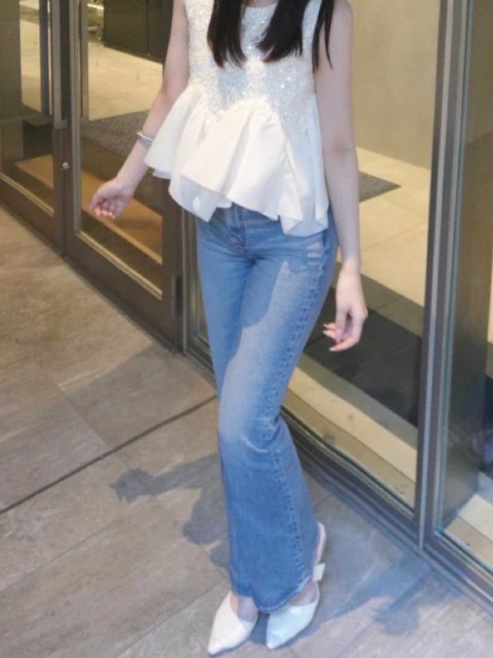 ホワイト系のパンプス、ホワイト系のシャツ/ブラウス、ブルー系のデニムパンツを着用したレディースの夏コーディネートの5枚目の写真