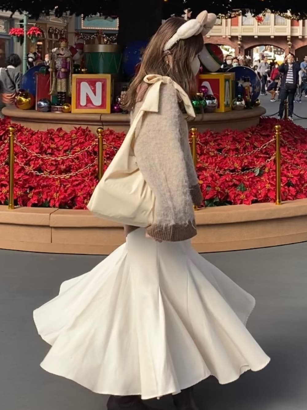 ブラウン系のニット/セーター、ホワイト系のスカート、ホワイト系のTシャツ/カットソーを着用したレディースの春コーディネートの2枚目の写真