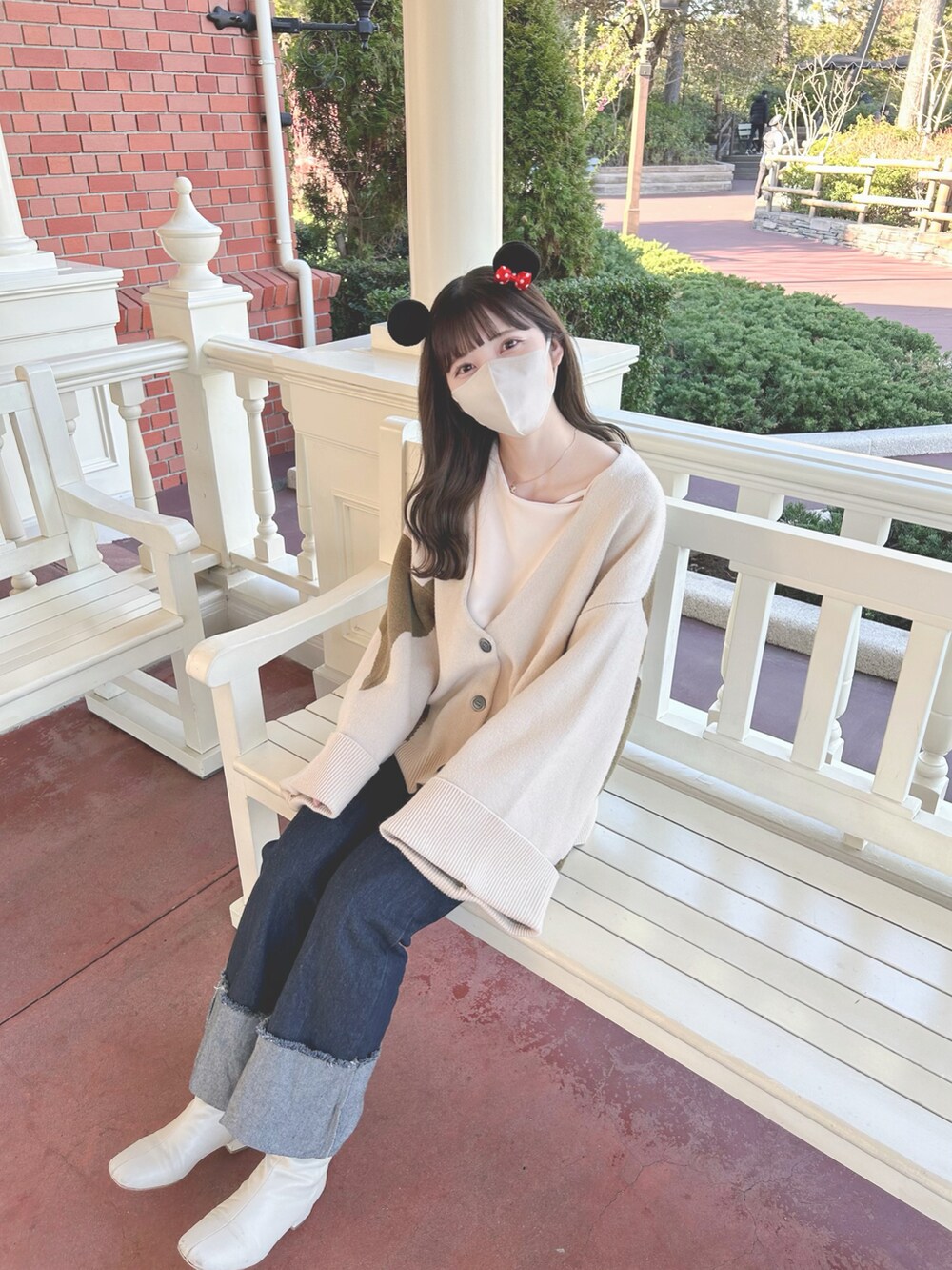 ベージュ系のスウェット、ベージュ系のカーディガン/ボレロ、ブルー系のデニムパンツを着用したレディースの春コーディネートの2枚目の写真