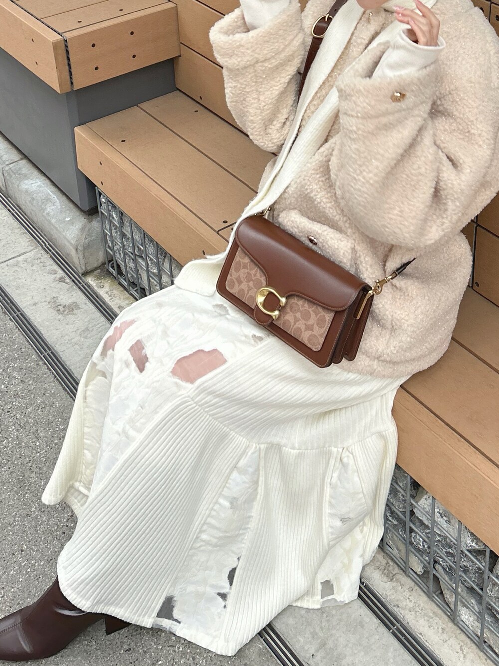 ベージュ系のブルゾン、ホワイト系のスカート、ブラウン系のブーツを着用したレディースの冬コーディネートの2枚目の写真