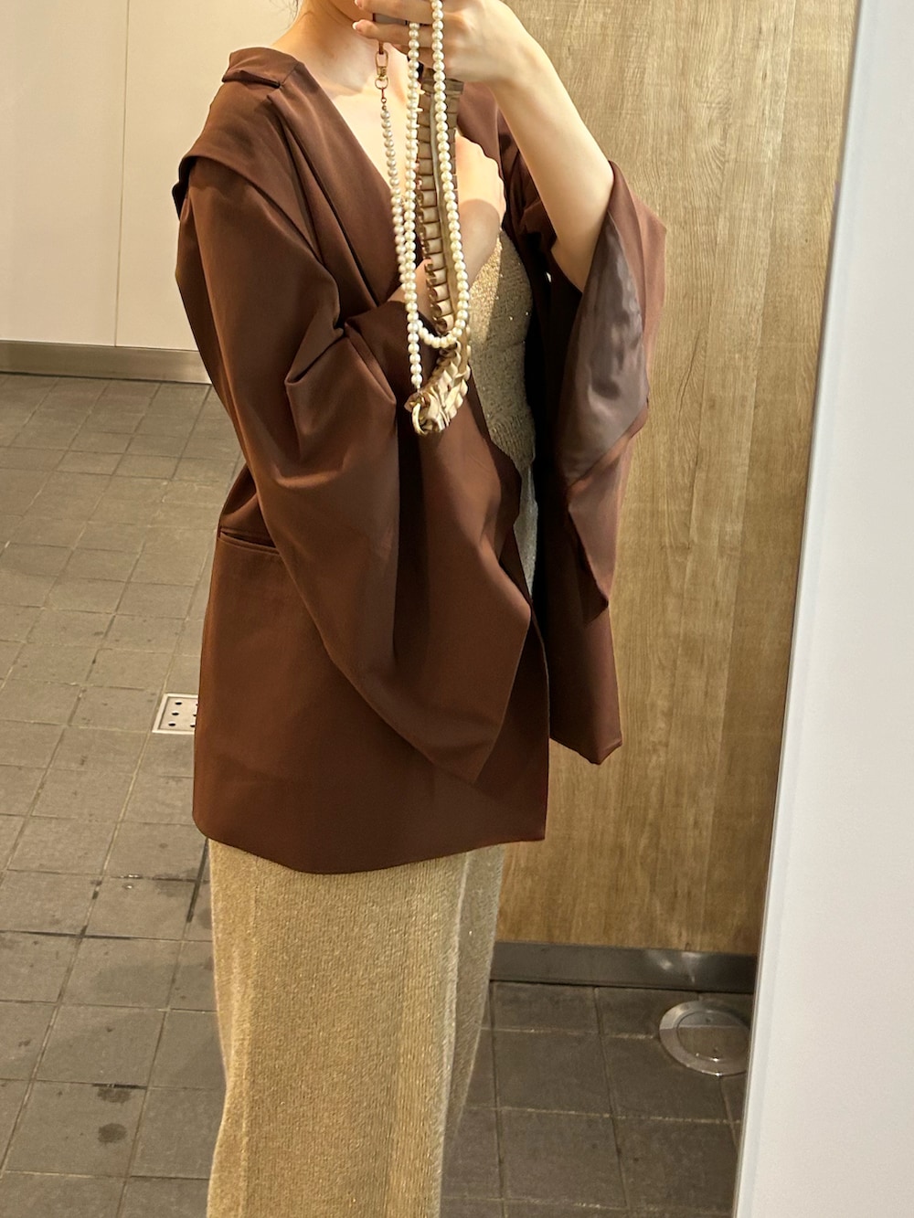 ベージュ系のスカート、ベージュ系のキャミソール、ブラウン系のジャケット/アウターを着用したレディースの秋コーディネートの2枚目の写真