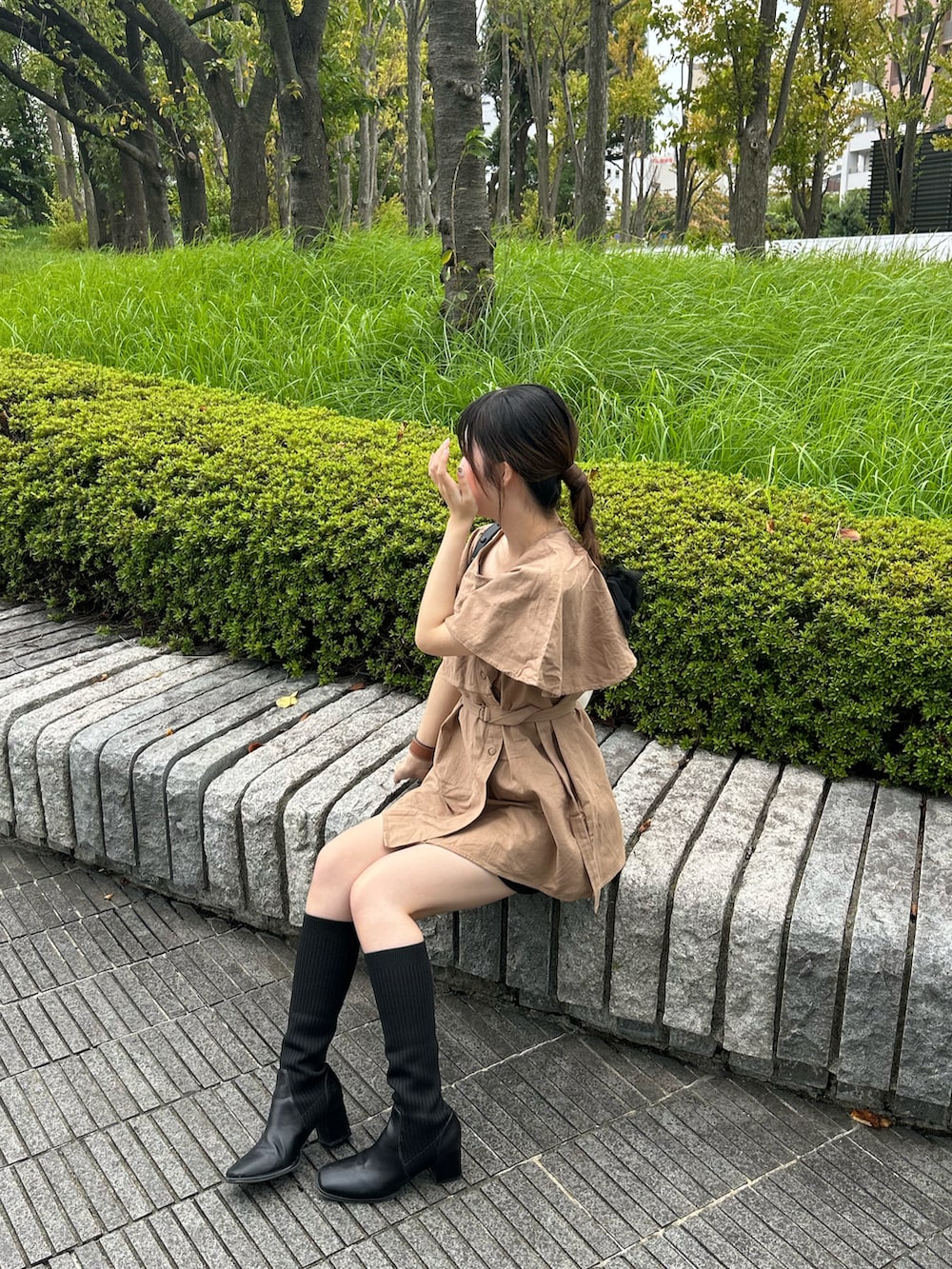 ブラウン系のベスト、ブラック系のパンツ、ホワイト系のバッグを着用したレディースの秋コーディネートの2枚目の写真